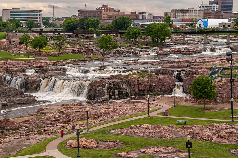 Sioux Falls, SD - View of Waterfalls in Park and City in Background